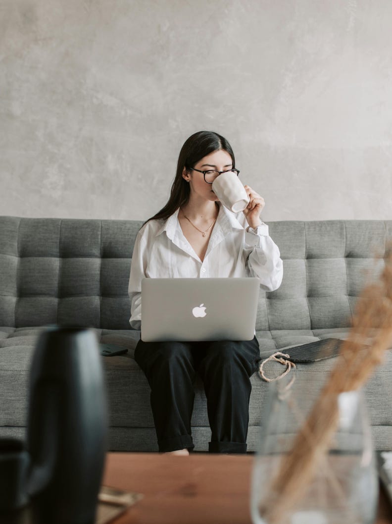 Woman Drinking Coffee While Working With Laptop